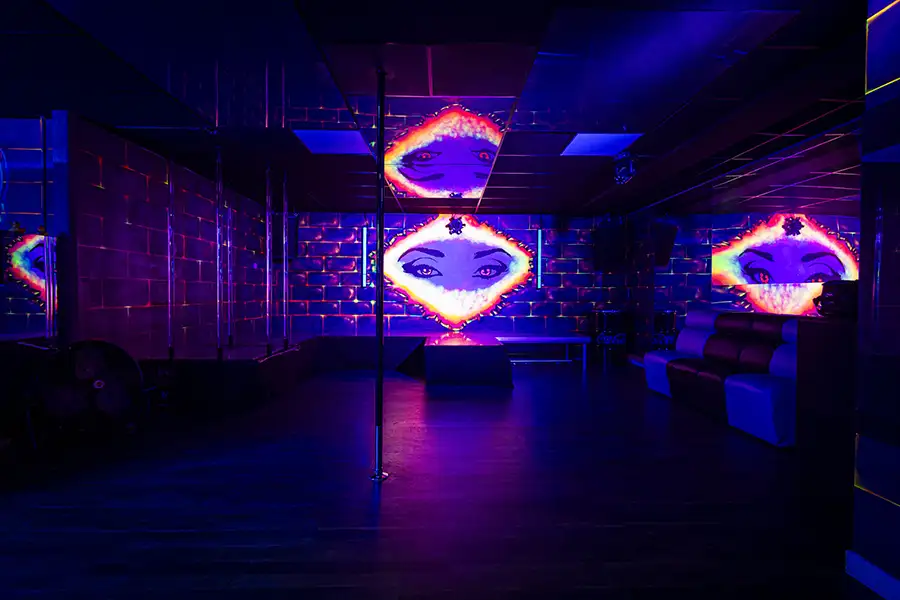 Salon aux miroirs néon du L’Ôlà, club libertin à Bruges